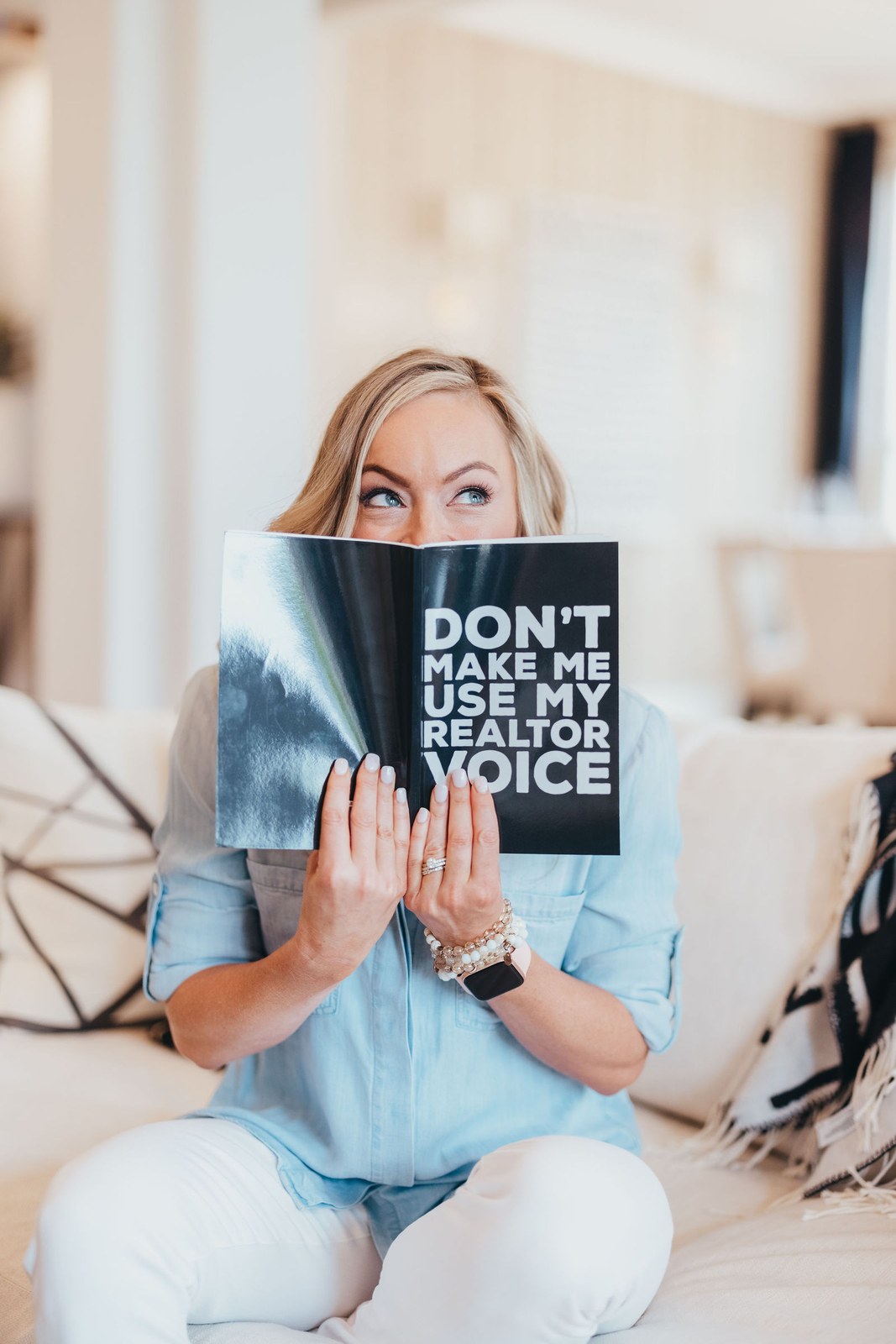 Kaitlin Lovern, North Dallas REALTOR, in a chambray shirt reading a magazine, serving Prosper, TX