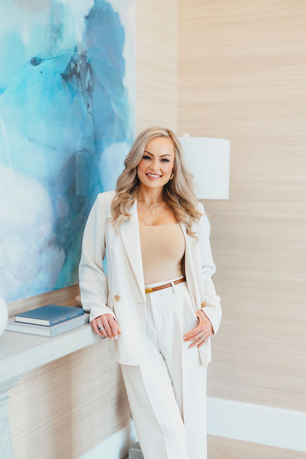 Kaitlin Lovern, North Dallas REALTOR, in a cream suit beside a home archway, serving McKinney, TX