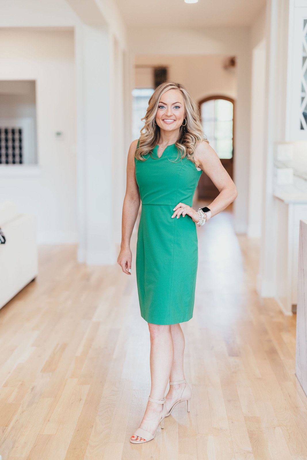Kaitlin Lovern, North Dallas REALTOR, in a green dress in a home hallway, serving Plano, TX